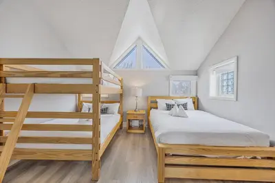 a bedroom with two bunk beds and a ladder at Slopeside Hideout Ski-In Ski-Out Walk to Village in Blue Mountains