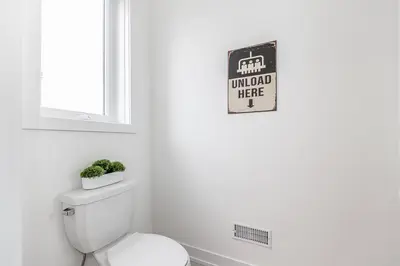 a bathroom with a toilet and a sign on the wall at Modern Luxury Townhome Walk to Blue Shuttle in Blue Mountains