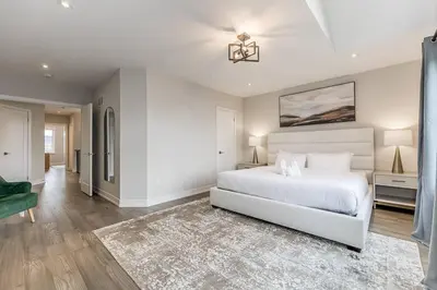 a white bedroom with a white bed and a green couch at Modern Luxury Townhome Walk to Blue Shuttle in Blue Mountains