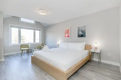 a bedroom with a large white bed and a window at Family Townhouse Walk-Shuttle to Blue Fire Pit in Blue Mountains