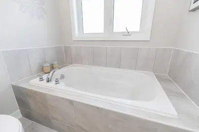 a white bath tub in a bathroom with a window at Family Townhouse Walk-Shuttle to Blue Fire Pit in Blue Mountains