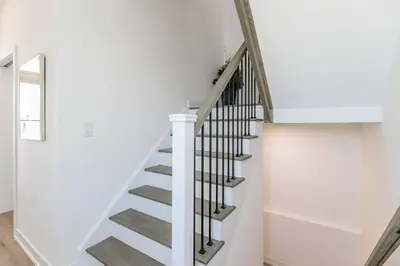 a staircase in a house with white walls at Blue Mtn Village Retreat Walk to Blue - Shuttle in Collingwood