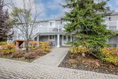 a large white house with a tree in front of it at Alpine Cove - Condo in Collingwood - Sleeps 6 in Collingwood