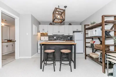 a kitchen with a table and two bar stools at Alpine Cove - Condo in Collingwood - Sleeps 6 in Collingwood