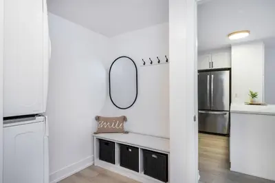 a white kitchen with a mirror on the wall at Cranberry Apres Nest Bright Reno Near Blue Mtn in Collingwood