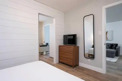 a bedroom with a mirror and a tv on a dresser at The Fox Den - Modern Condo Collingwood - Sleeps 5 in Collingwood
