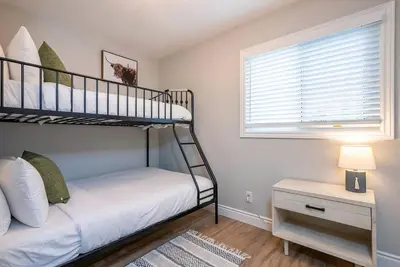 a bedroom with two bunk beds and a window at The Fox Den - Modern Condo Collingwood - Sleeps 5 in Collingwood