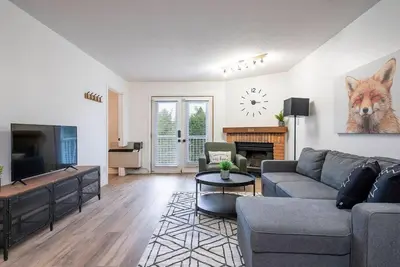 a living room with a couch and a tv at The Fox Den - Modern Condo Collingwood - Sleeps 5 in Collingwood