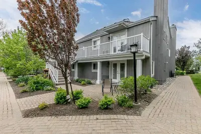 a gray house with a balcony and a street light at South Wind - Modern Condo in Collingwood - Sleep 5 in Collingwood