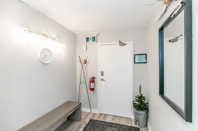 a hallway with white walls and a clock on the wall at The Nest - Walk to Blue Private Patio in Blue Mountains