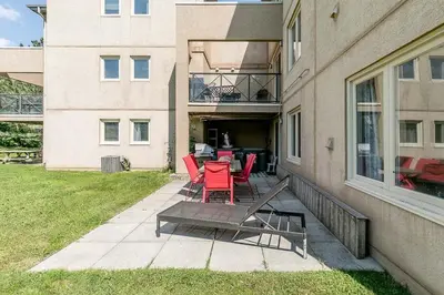 a patio with red chairs and a table in front of a building at The Nest - Walk to Blue Private Patio in Blue Mountains