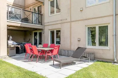 a patio with red chairs and a table and a building at The Nest - Walk to Blue Private Patio in Blue Mountains