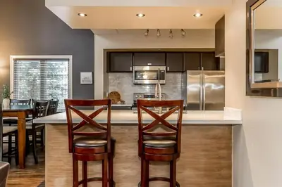 a kitchen with a bar with chairs and a counter top at Mountain Walk Retreat - Walk to Blue Patio area in Blue Mountains