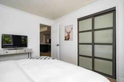 a bedroom with a bed with a sliding glass door at Sweet Retreat Ski-In Ski-Out - Pool & Hot Tub in Blue Mountains