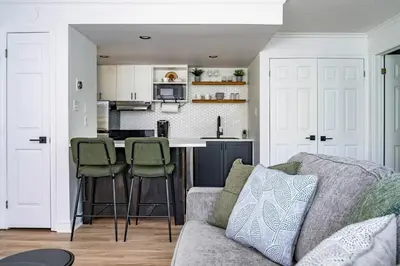 a living room with a couch and a kitchen at Sweet Retreat Ski-In Ski-Out - Pool & Hot Tub in Blue Mountains