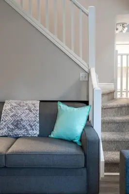a blue pillow sitting on a couch next to a staircase at Tranquility Oasis Ski-In Out Hot Tub Shuttle in Blue Mountains