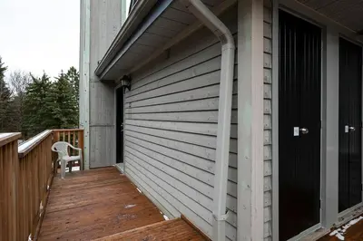 a wooden deck with a chair on a house at Tranquility Oasis Ski-In Out Hot Tub Shuttle in Blue Mountains