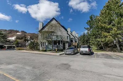 a house with two cars parked in a parking lot at Tranquility Oasis Ski-In Out Hot Tub Shuttle in Blue Mountains