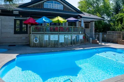 a house with a swimming pool with umbrellas at Tranquility Oasis Ski-In Out Hot Tub Shuttle in Blue Mountains