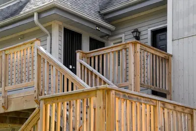 a wooden deck in front of a house at Stay A While Ski-In-Out Hot Tub & Shuttle in Blue Mountains
