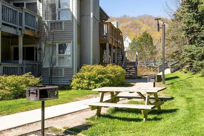 a picnic table in the grass in front of a building at Stay A While Ski-In-Out Hot Tub & Shuttle in Blue Mountains
