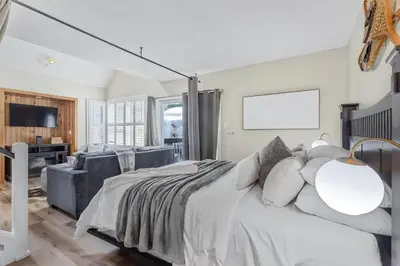 a bedroom with a large bed and a tv at Cozy Nest Ski-In-Out Pool Hot Tub Shuttle in Blue Mountains