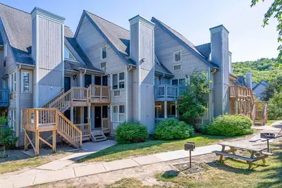 a large house with a bench in front of it at Cozy Nest Ski-In-Out Pool Hot Tub Shuttle in Blue Mountains