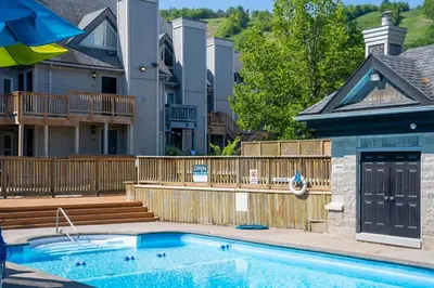 a swimming pool in front of a house at Cozy Nest Ski-In-Out Pool Hot Tub Shuttle in Blue Mountains