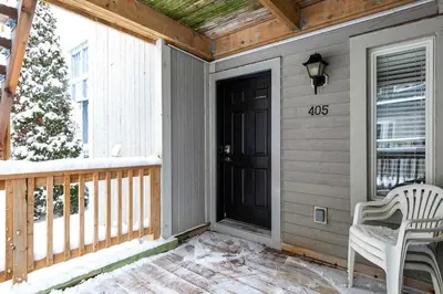 a porch with a black door and a white chair at Heavenly Hideaway Ski-In-Out Pool Shuttle in Blue Mountains