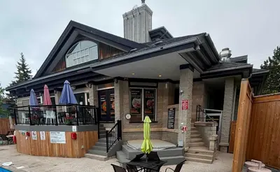 a house with a patio with umbrellas on the porch at Heavenly Hideaway Ski-In-Out Pool Shuttle in Blue Mountains