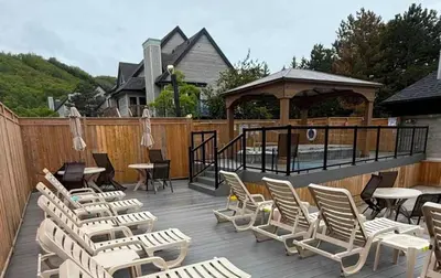 a deck with chairs and tables and a gazebo at Heavenly Hideaway Ski-In-Out Pool Shuttle in Blue Mountains
