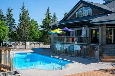 a house with a swimming pool in front of a house at Mountain Peaks Ski-In-Out Pool Shuttle in Blue Mountains