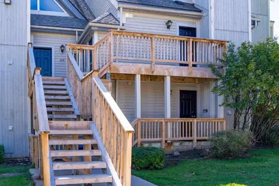 a deck with stairs leading up to a house at Foxwood Retreat - Shuttle to Blue Pool & Hot Tub in Blue Mountains