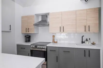 a kitchen with white cabinets and a stove and a sink at Arrowhead Retreat Ski-In-Out Pool Shuttle in Blue Mountains
