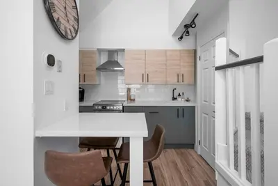 a kitchen with a white counter and chairs in it at Arrowhead Retreat Ski-In-Out Pool Shuttle in Blue Mountains