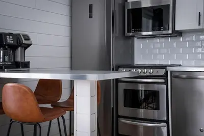 a kitchen with a table and chairs in a kitchen at Northern Peaks Ski In-Out Hot Tub Shuttle Access in Blue Mountains