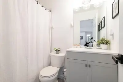 a white bathroom with a toilet and a sink at Northern Peaks Ski In-Out Hot Tub Shuttle Access in Blue Mountains