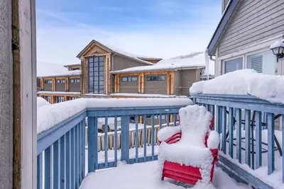 a red chair sitting on a balcony covered in snow at Northern Peaks Ski In-Out Hot Tub Shuttle Access in Blue Mountains