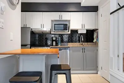 a kitchen with white cabinets and a counter with a microwave at Mountainside Escape Ski-In-Out Pool Shuttle in Blue Mountains