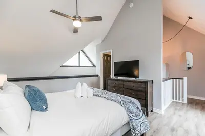 a bedroom with a white bed and a tv at Mountain View Ski-In-Out Pool Shuttle to Blue in Blue Mountains