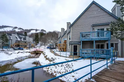 a house with a blue railing in the snow at Mountain View Ski-In-Out Pool Shuttle to Blue in Blue Mountains