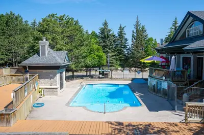 a swimming pool in a yard next to a house at Mountain View Ski-In-Out Pool Shuttle to Blue in Blue Mountains