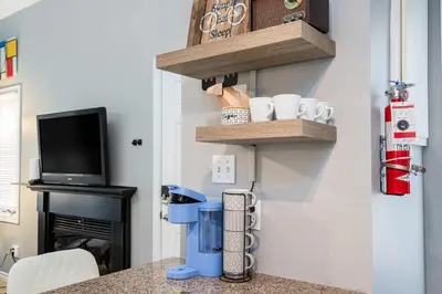 a kitchen with wooden shelves on the wall at Blue Haven Ski-In-Out Pool Hot Tub Shuttle in Blue Mountains