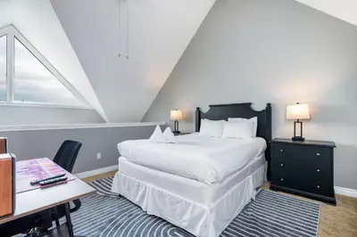 a bedroom with a large white bed and a desk at Blue Haven Ski-In-Out Pool Hot Tub Shuttle in Blue Mountains
