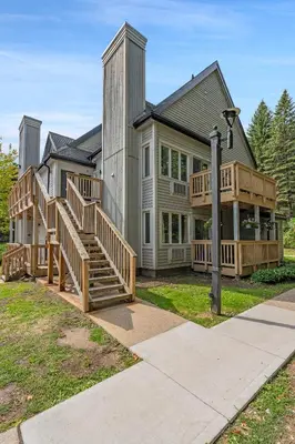 a large house with wooden stairs in front of it at Blue Haven Ski-In-Out Pool Hot Tub Shuttle in Blue Mountains