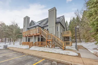 a large house with a large deck in the snow at Blue Haven Ski-In-Out Pool Hot Tub Shuttle in Blue Mountains