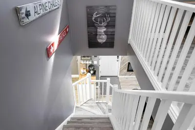 a hallway with stairs and a sign on the wall at Fox Ridge - Ski-In-Out Pool Hot Tub Shuttle in Blue Mountains