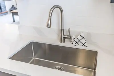 a stainless steel sink in a white kitchen at Rivergrass Oasis Across from Blue Mtn Hot Tub in Blue Mountains