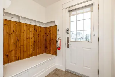 a bathroom with a white door and a wooden wall at Rivergrass Oasis Across from Blue Mtn Hot Tub in Blue Mountains