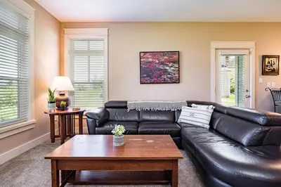 a living room with a leather couch and a table at Hickory Ridge Across Blue Mtn Hot Tub Shuttle in Blue Mountains